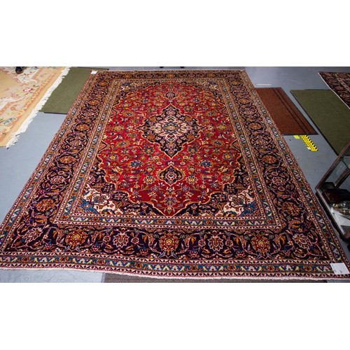 91 - RUST GROUND PERSIAN WOOL RUG. 340 X 260CM