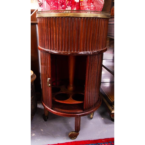 154 - MAHOGANY CIRCULAR DRINKS TROLLEY WITH TAMBOUR SIDE + BRASS GALLERY. 82CM HIGH . 46CM DIAM.