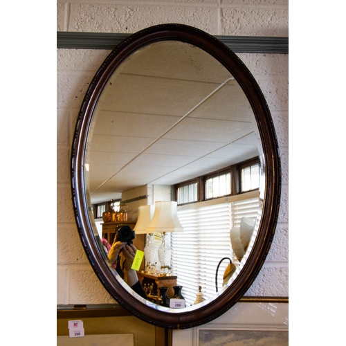 286 - CARVED MAHOGANY OVAL BEVELLED MIRROR