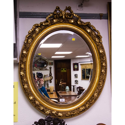 73 - GILDED OVAL RIBBON TOP MIRROR . 68 X 86.