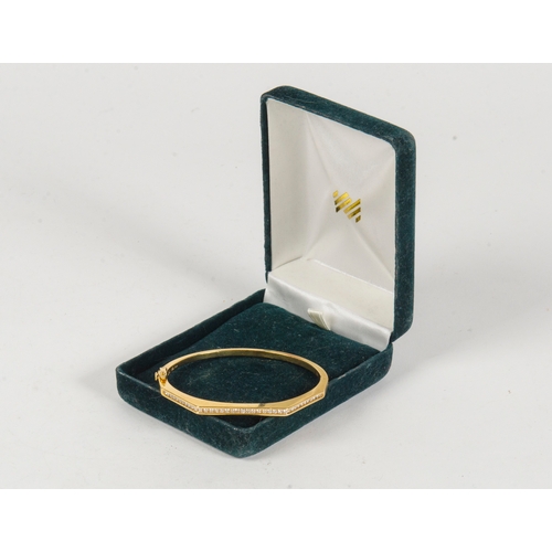 73 - A ladies Gold and Diamond set half hoop bangle contained in original box.
24.4 grams.