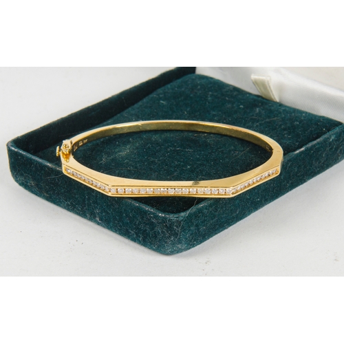 73 - A ladies Gold and Diamond set half hoop bangle contained in original box.
24.4 grams.