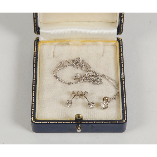 74 - A Pair of white gold and diamond set earrings, along with the matching single diamond necklace, on a... 