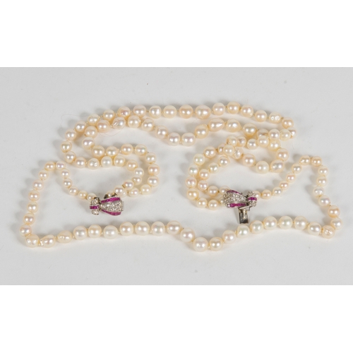 76 - An Art Deco Three Strand Pearl Necklace, with a diamond and ruby set clasp, platinum mounted.