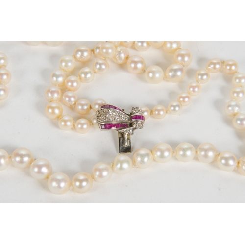 76 - An Art Deco Three Strand Pearl Necklace, with a diamond and ruby set clasp, platinum mounted.