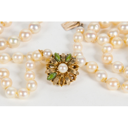 77 - A Two Strand Cultured Pearl Necklace, with a 9 carat clasp, set with green stones.