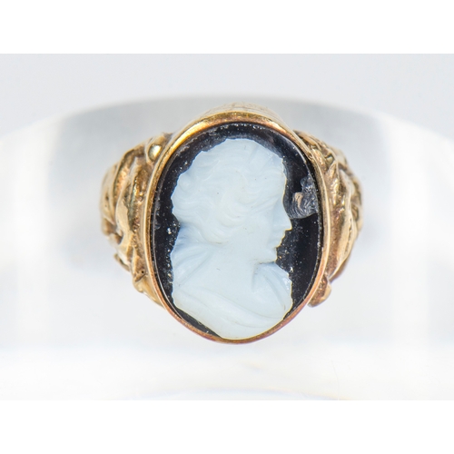 82 - A Gentleman's 9 Carat Gold Ring, set with floral decorated shoulders and agate carving of a mans hea... 