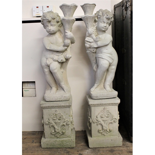 587 - Two concrete garden cherub ornaments.