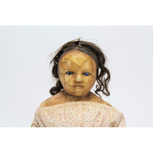 617 - A Victorian wax headed doll, with piercing blue eyes, decorated in a period dress, human hair, pleas... 