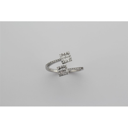 202 - A ladies 18 carat white gold ring, set with two cross over diamond sectioned and panelled clusters.