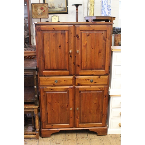 286 - A pine two door linen cabinet, fitted two drawers, resting on bracket feet.