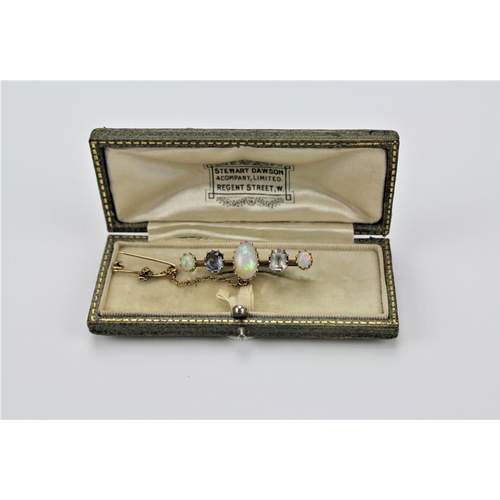 137 - A Victorian opal brooch, three graduated opals and two coloured gem stones.