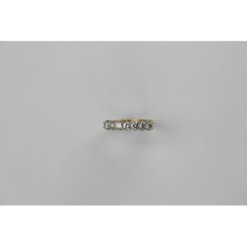 105 - A ladies 18 carat diamond set dress ring, mounted with seven diamonds, in a half hoop setting. Size ... 