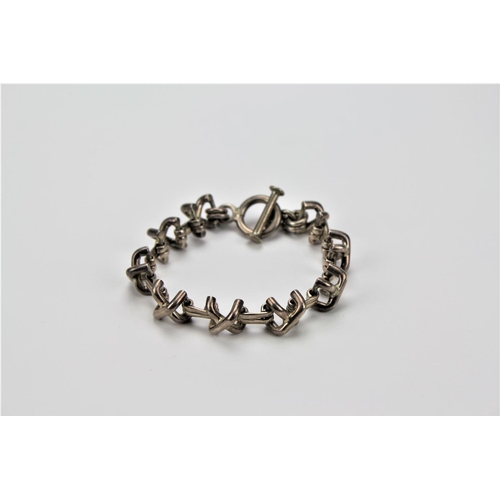 127 - A Silver 925 marked cross over design bracelet.