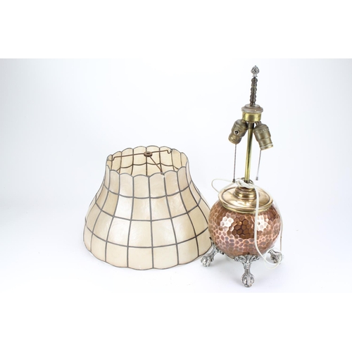 679 - An American silver plated table lamp, copper, hand beaten, resting on eagle claw feet, double rise a... 