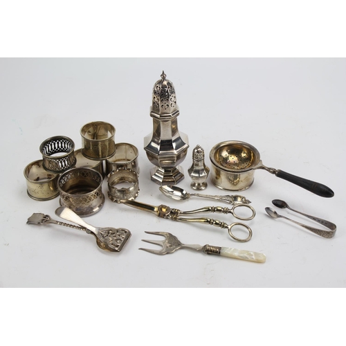 67 - A pair of silver plated tongs, napkin rings etc.