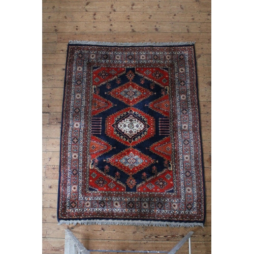 413 - A Red ground and floral bordered central medallion Persian design carpet.