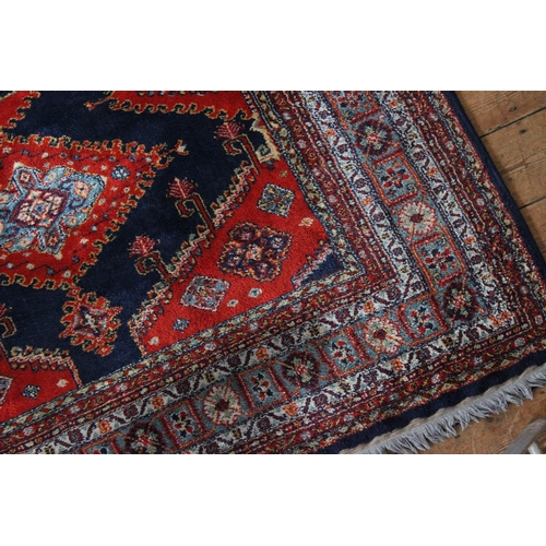 413 - A Red ground and floral bordered central medallion Persian design carpet.