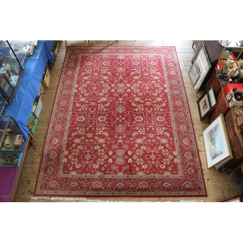 417A - A large floral patterned medallion carpet, decorated in red ground.