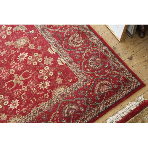 417A - A large floral patterned medallion carpet, decorated in red ground.