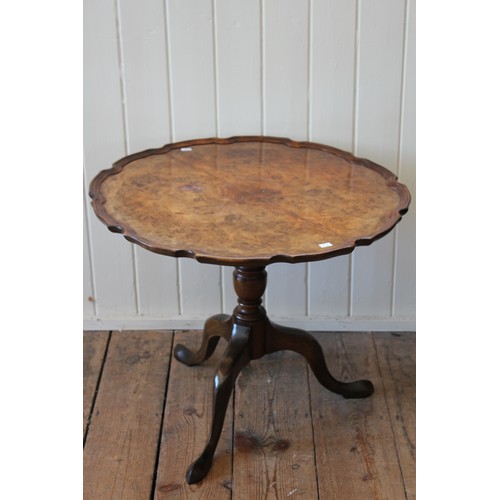 347 - A Walnut veneered pie crust table, resting on a tripod base. Measuring: 62cms across x 51cms High.