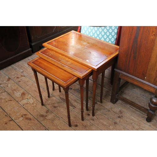 384 - A Nest of Three Graduated Yew Wood Tables standing on Shaped Legs.