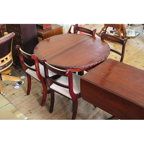 404 - A Round Extendable table with carved edge along with 4 matching chairs with pink covers.