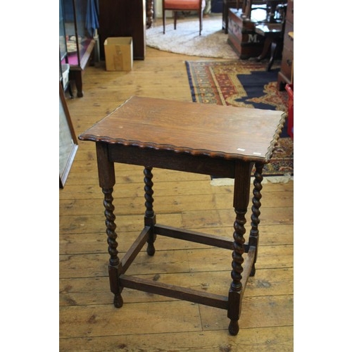 454 - A Oak shaped top occasional table resting on barley twist legs.