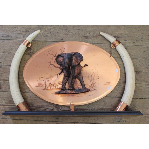 684 - A  Rhodesian Craft industry pair of Resin Tusks with copper study of an elephant with a wooden base.