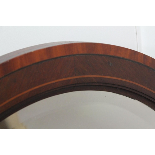 461 - An Edwardian Mahogany and satinwood inlaid oval framed bevelled mirror.