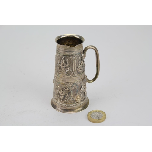 77 - An Indian Silver coloured White Metal Spirit Jigger decorated with female subjects. Weighing: 90g.