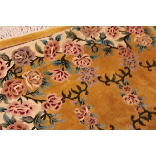 267 - A Large Chinese yellow ground floral and ribbon woven shaped and fringed carpet. Measuring: 274cms x... 