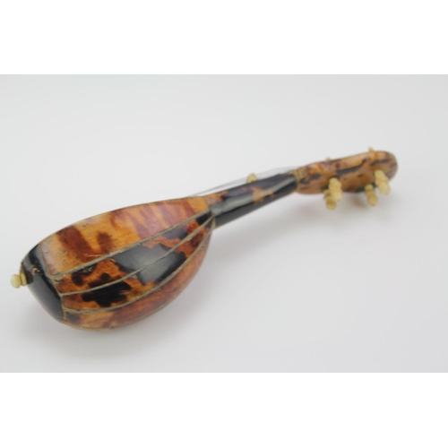 566 - A Spanish Tortoise shell effect and mother of pearl inlaid Mandolin. 14cm long.