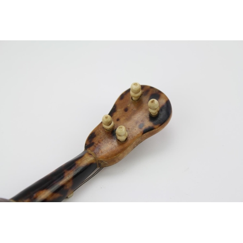 566 - A Spanish Tortoise shell effect and mother of pearl inlaid Mandolin. 14cm long.