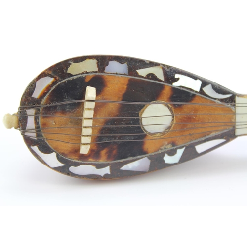 566 - A Spanish Tortoise shell effect and mother of pearl inlaid Mandolin. 14cm long.