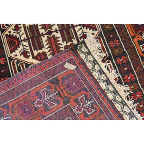 285 - A Red and Blue Geometric Shaped Rug with fringed edge. Measuring: 215 cm x 115 cm.