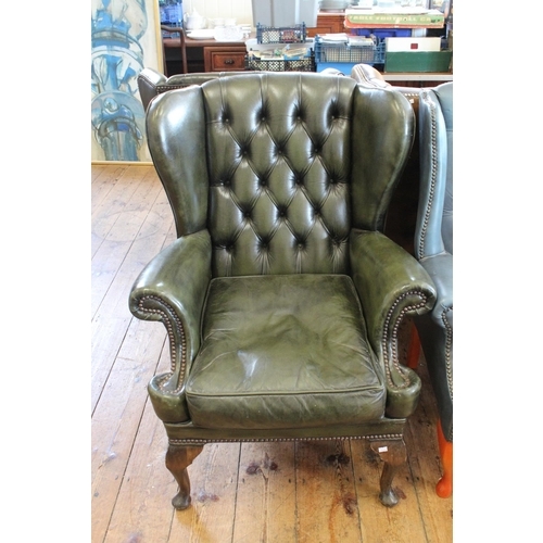 366 - An Over Stuffed Green Leather Fire Side Chair with semi winged form.