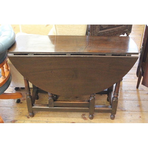 370 - An Antique oak gate leg table resting on turned legs.