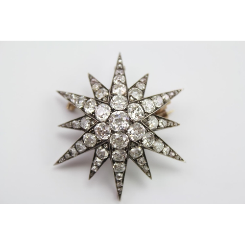 171 - A Victorian 9 carat diamond mounted starburst brooch, mounted with a cluster of 7 central diamonds a... 