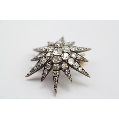 171 - A Victorian 9 carat diamond mounted starburst brooch, mounted with a cluster of 7 central diamonds a... 