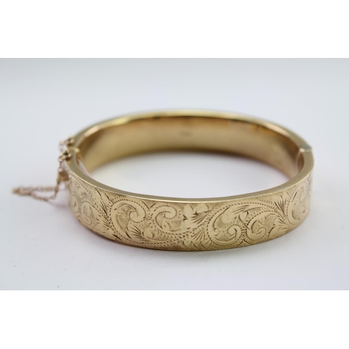 221 - A ladies 9 carat Gold engraved bangle. Weighing approximately 17.2g.