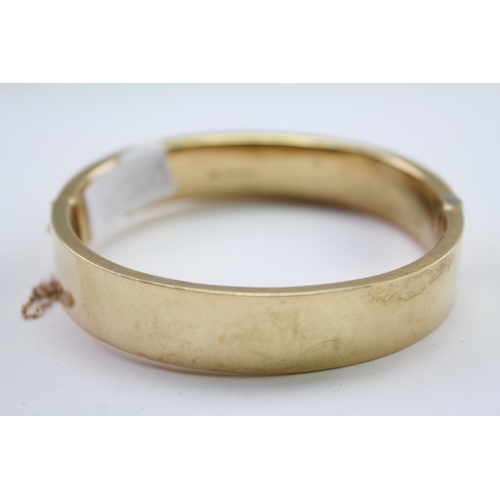 221 - A ladies 9 carat Gold engraved bangle. Weighing approximately 17.2g.