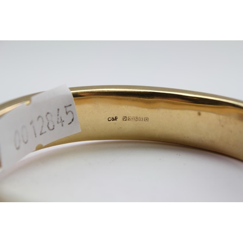 221 - A ladies 9 carat Gold engraved bangle. Weighing approximately 17.2g.