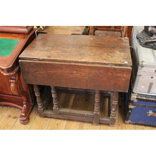 422 - An Oak Drop-Flap Gate Leg Table resting on turned legs.