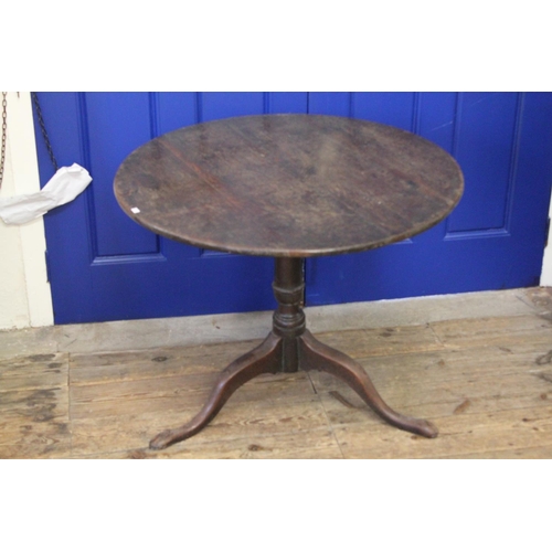 424 - A Georgian Circular Oak Topped Drop-Flap Wine Table resting on pad feet. Measuring: 82 cms across x ... 