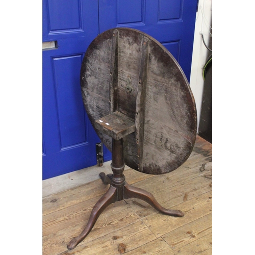 424 - A Georgian Circular Oak Topped Drop-Flap Wine Table resting on pad feet. Measuring: 82 cms across x ... 