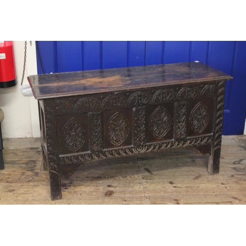 428 - An Antique Oak Coffer with carved panels and resting on elongated legs. Measuring: 121 cms across x ... 