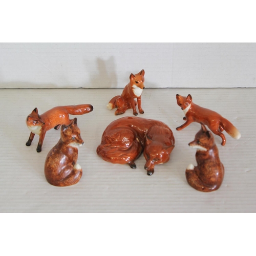 537 - A Beswick study of a fox along with other foxes. (One front leg damaged).