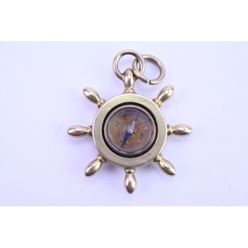 160 - An 18ct Gold Ship's Wheel Compass. Weighing: 6 grams.