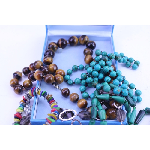 132 - A tiger eye bead necklace, two strings of beads, along with other items of costume jewellery.